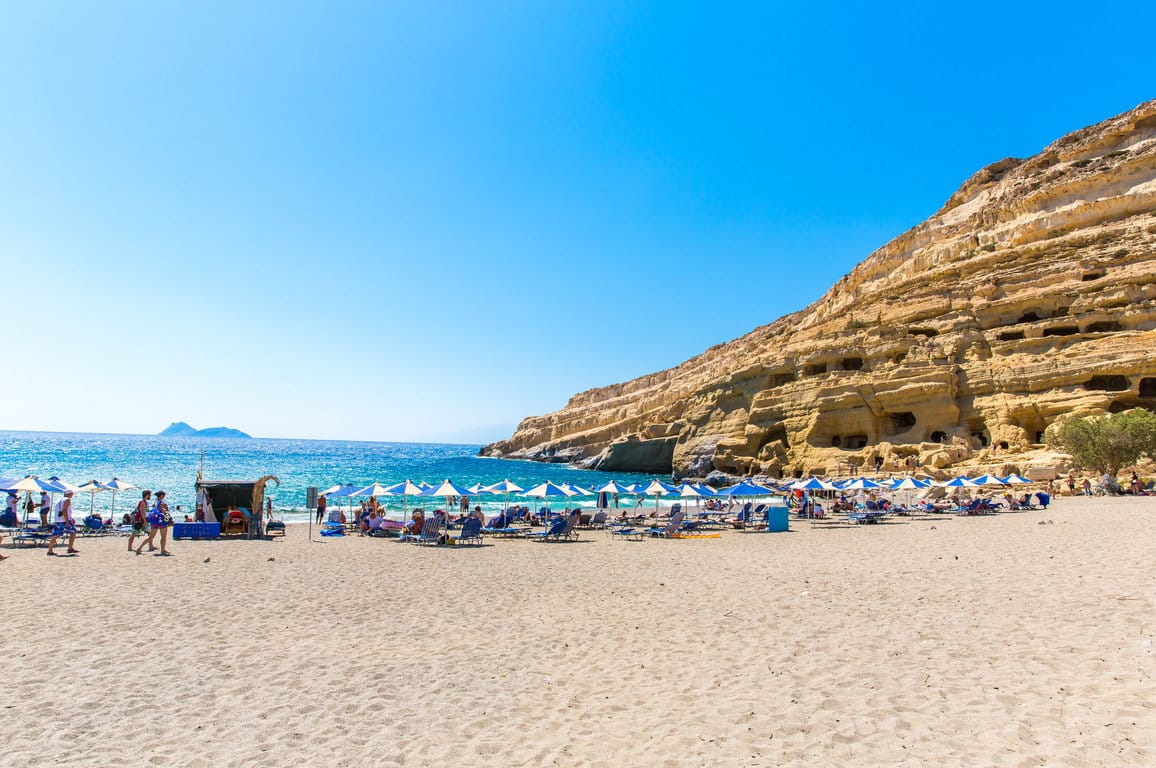 Pebbly beach Matala, Greece Crete. Matala has become famous for artificial Neolithic caves, carved in limestone rocks. During the 70's the caves were hosting an international hippie community Kreta: Matala-Bucht